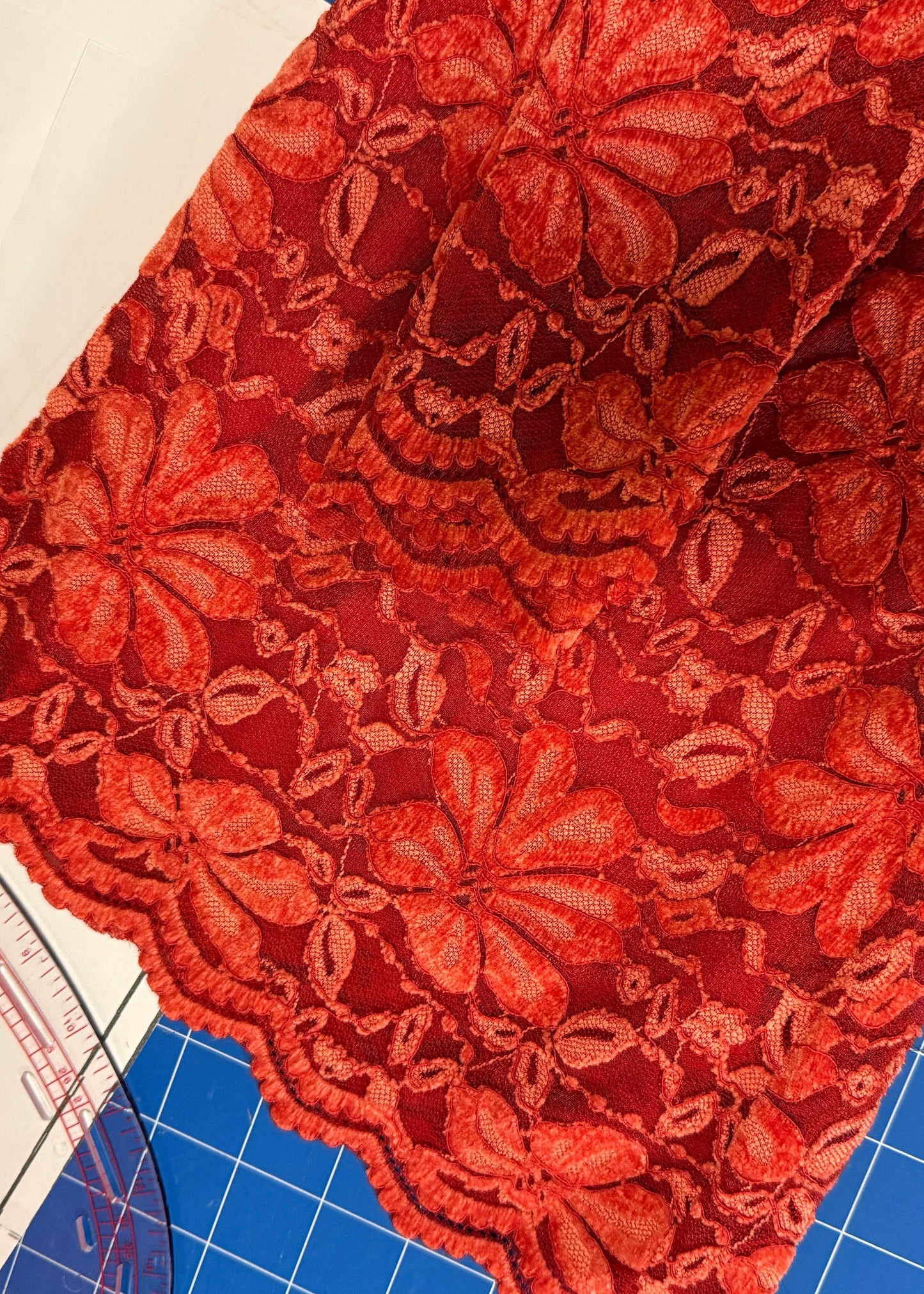 Red floral fabric on a cutting mat with measurement tools