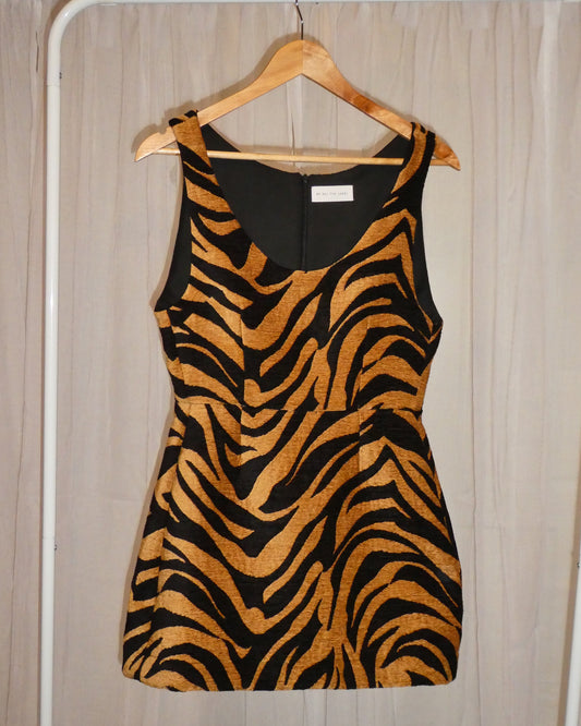Zebra print dress on a hanger against a neutral background