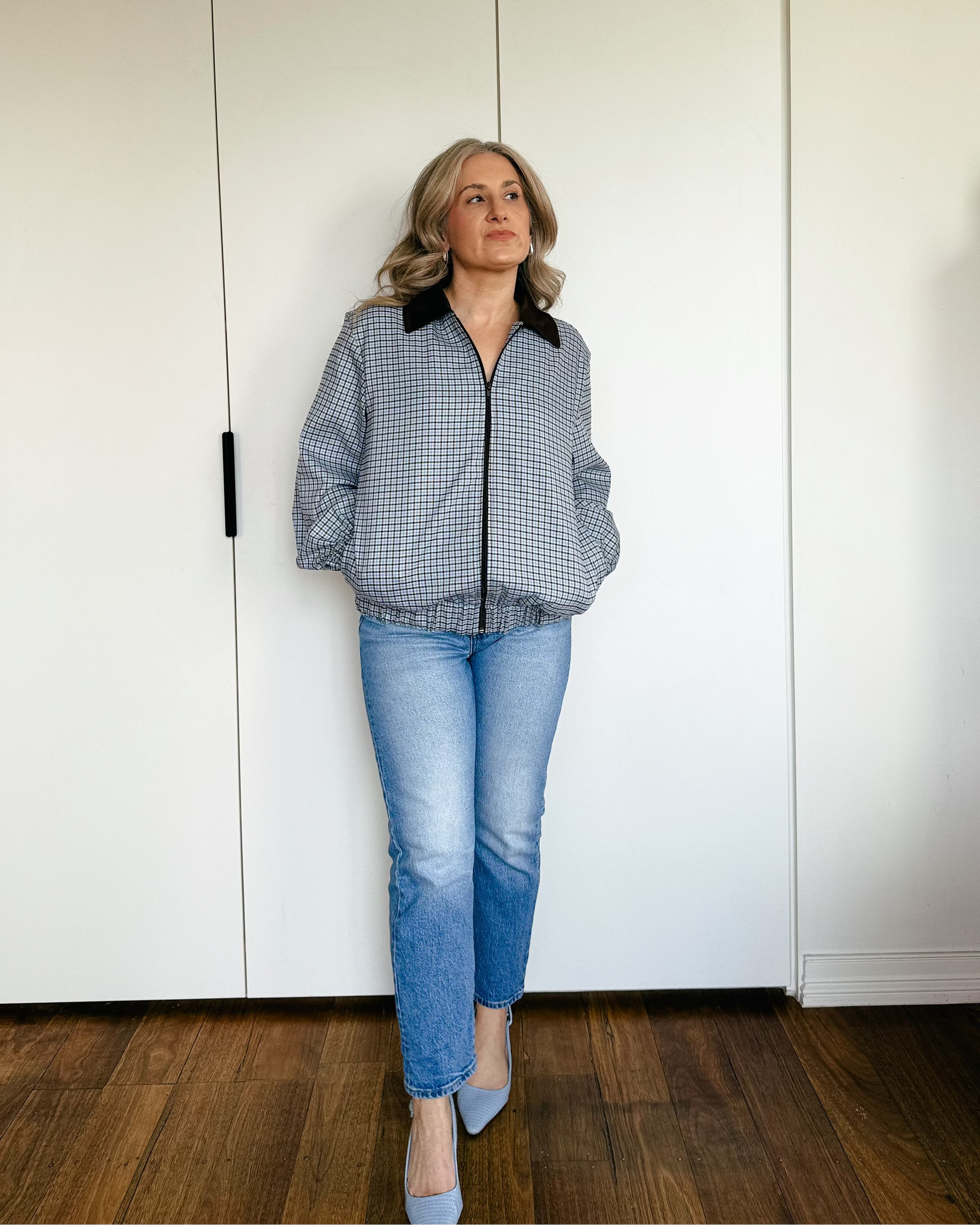 Model wearing The Tailored Bomber by By Bel in a powder blue heritage check with a contrast faux suede collar and relaxed silhouette.