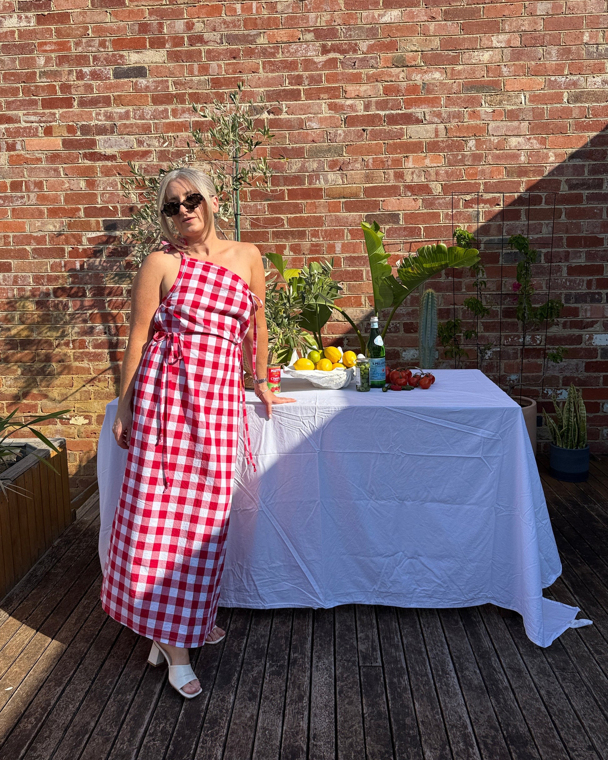 Red gingham summer maxi dress by By Bel featuring long flowing silhouette and relaxed fit for European summer styling.