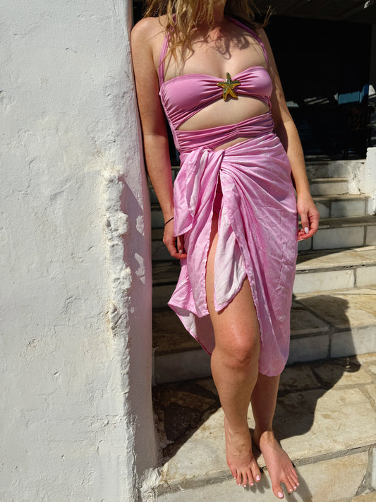 Person wearing a pink dress with a star design on a stone staircase.