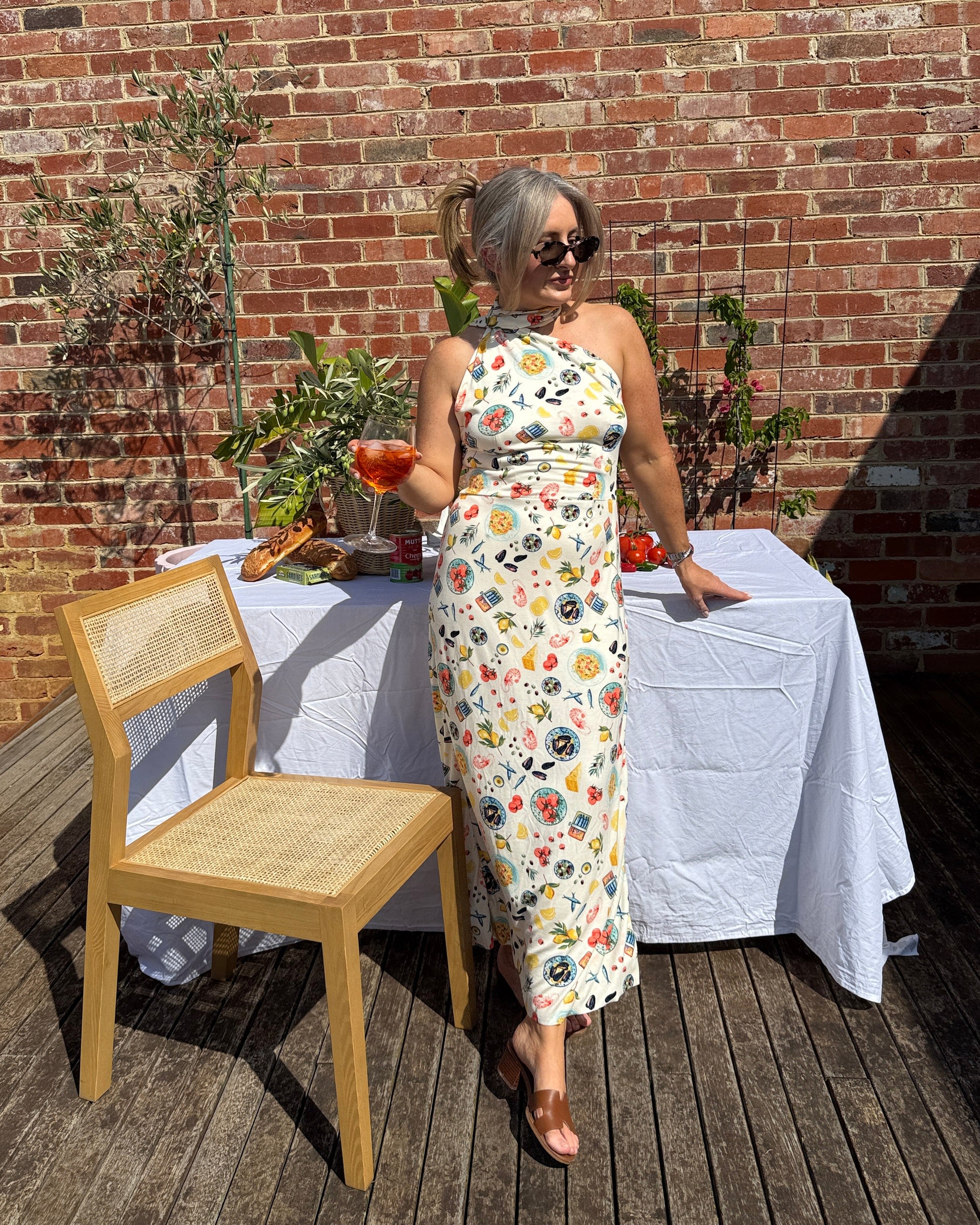 By Bel Sarinda one shoulder maxi dress in seafood print with long tie detail, styled for Mediterranean summer long lunch.