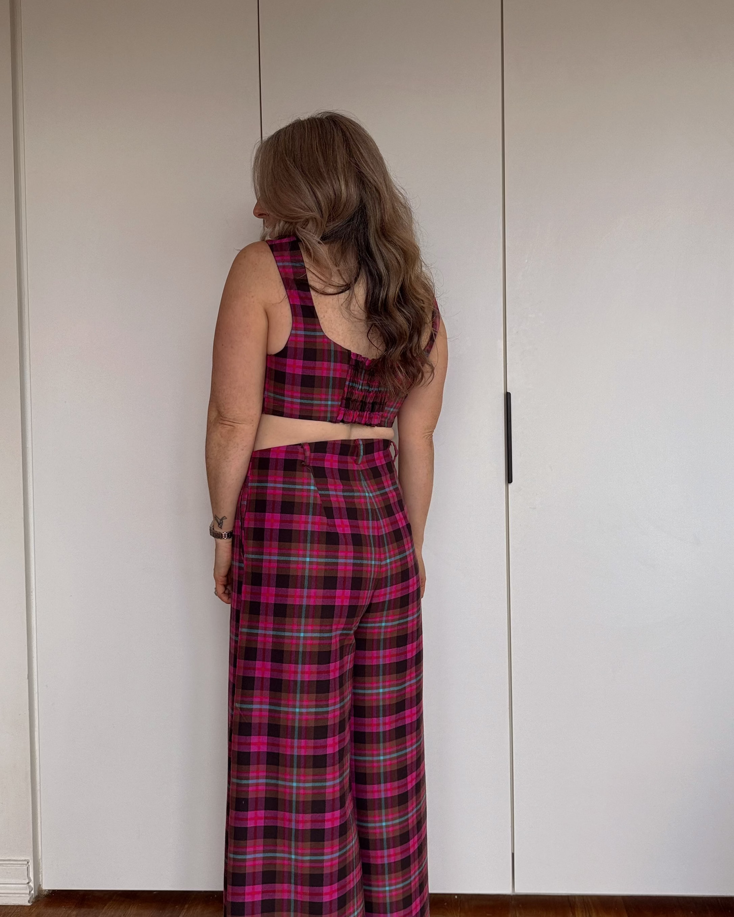 Model wearing The Tailored Crop by By Bel in a blush heritage tartan with a structured fit and square neckline.