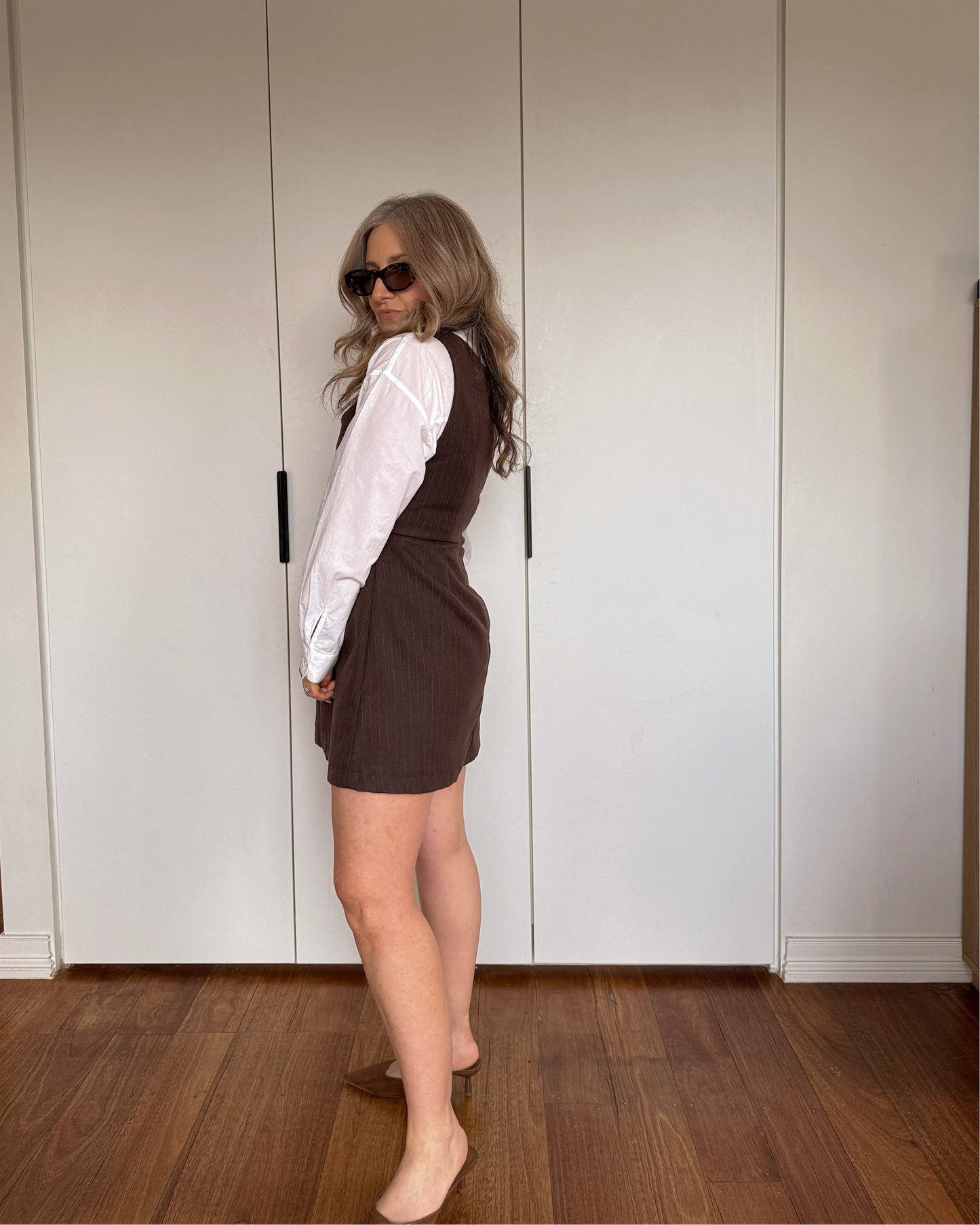 Structured espresso pinstripe mini dress by By Bel styled over a white shirt.