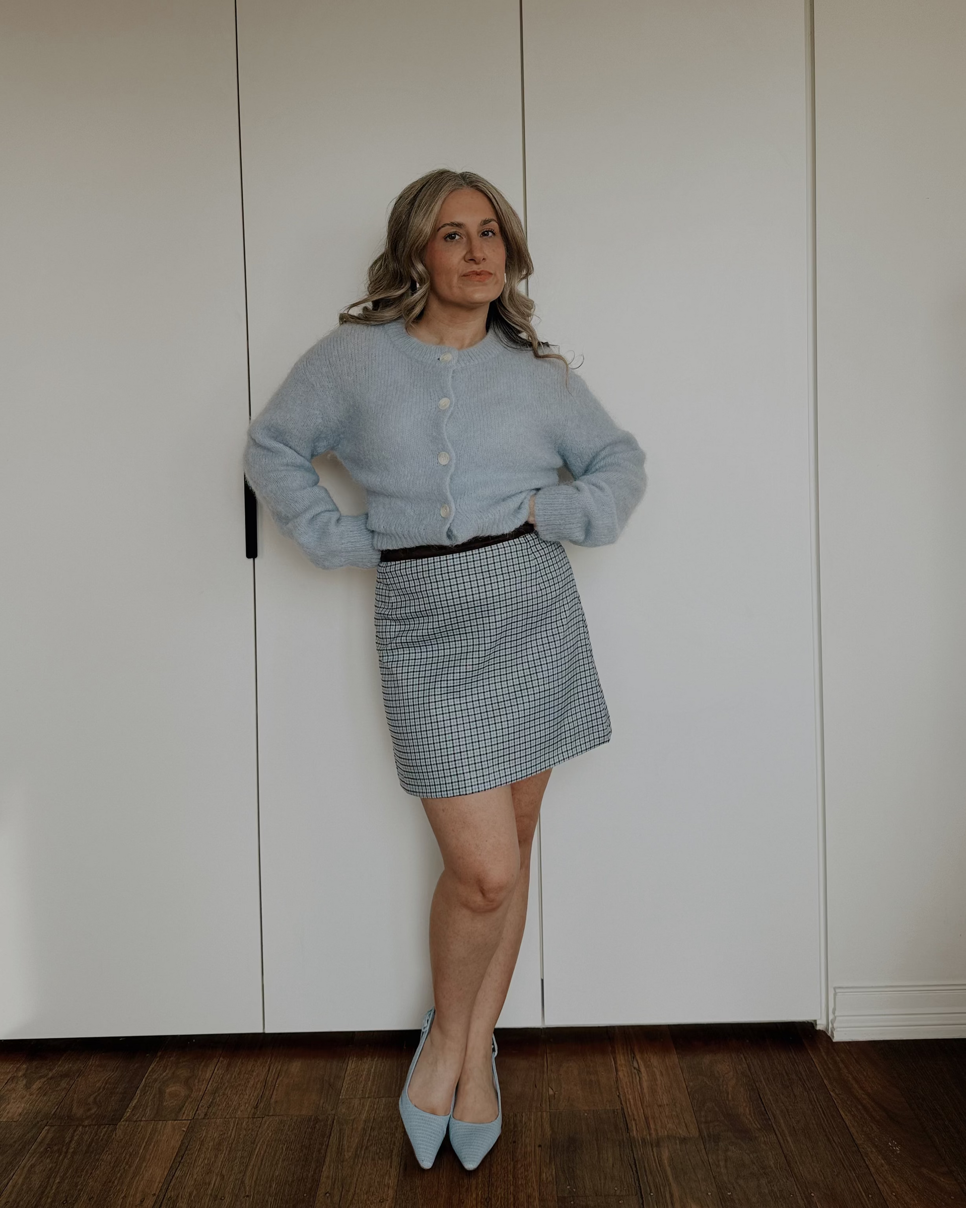 Model wearing The Tailored Mini Skirt by By Bel in a powder blue heritage check with a contrast faux suede waistband.