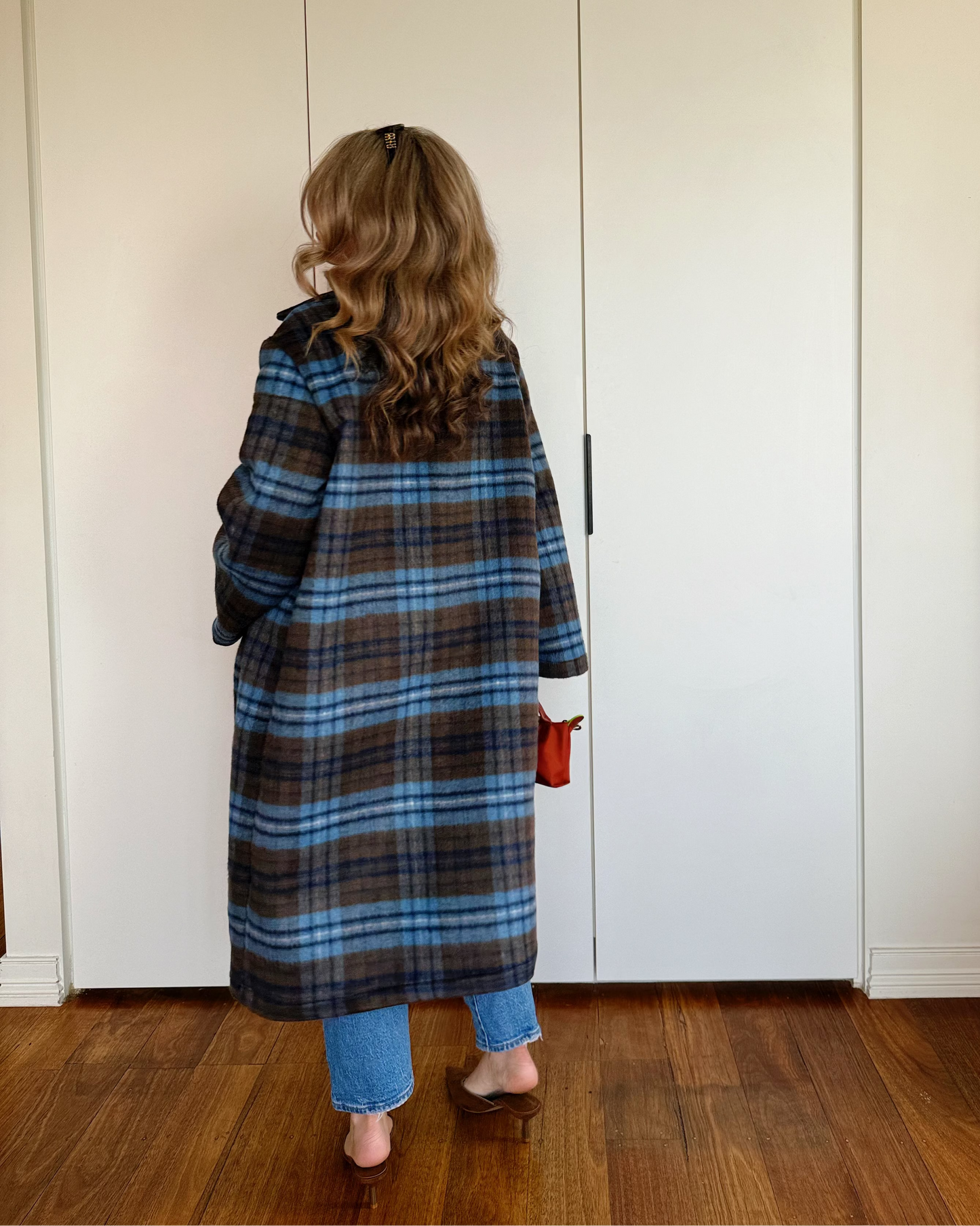 Model wearing The Tailored Coat by By Bel in an espresso and powder blue heritage check with a relaxed straight-cut silhouette