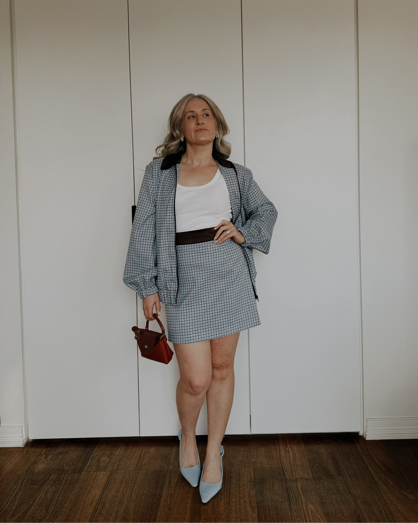 Model wearing The Tailored Mini Skirt by By Bel in a powder blue heritage check with a contrast faux suede waistband.