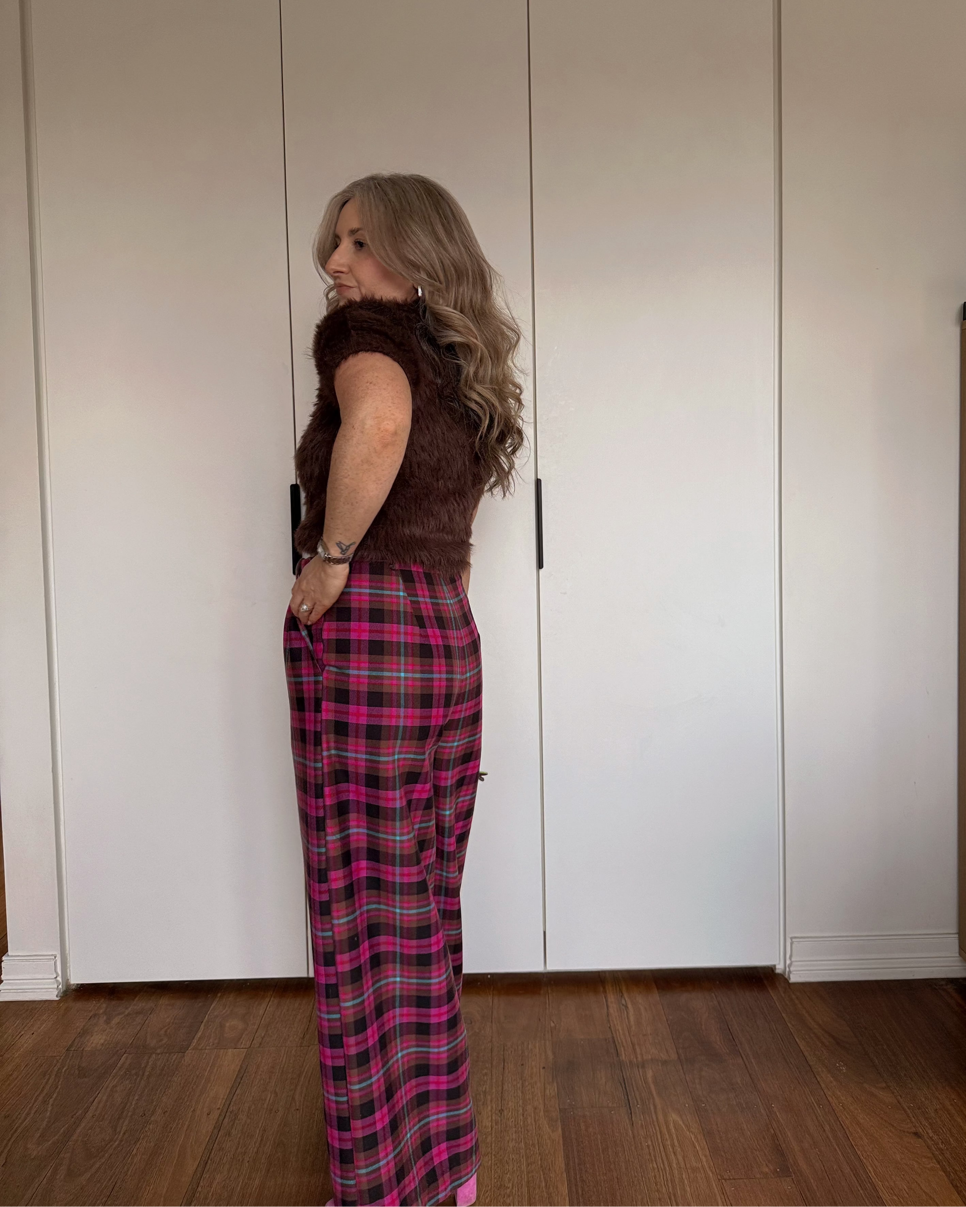 Model wearing The Tailored Trousers by By Bel in a blush heritage tartan with a high-waisted wide-leg tailored silhouette.