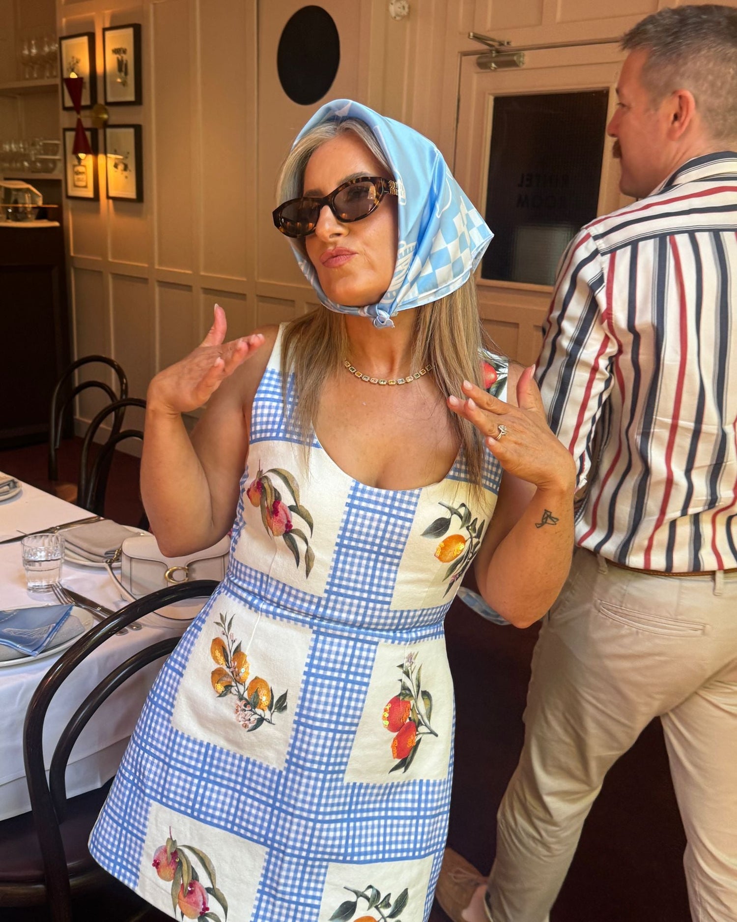 Woman in a checkered dress with floral patterns in a restaurant setting