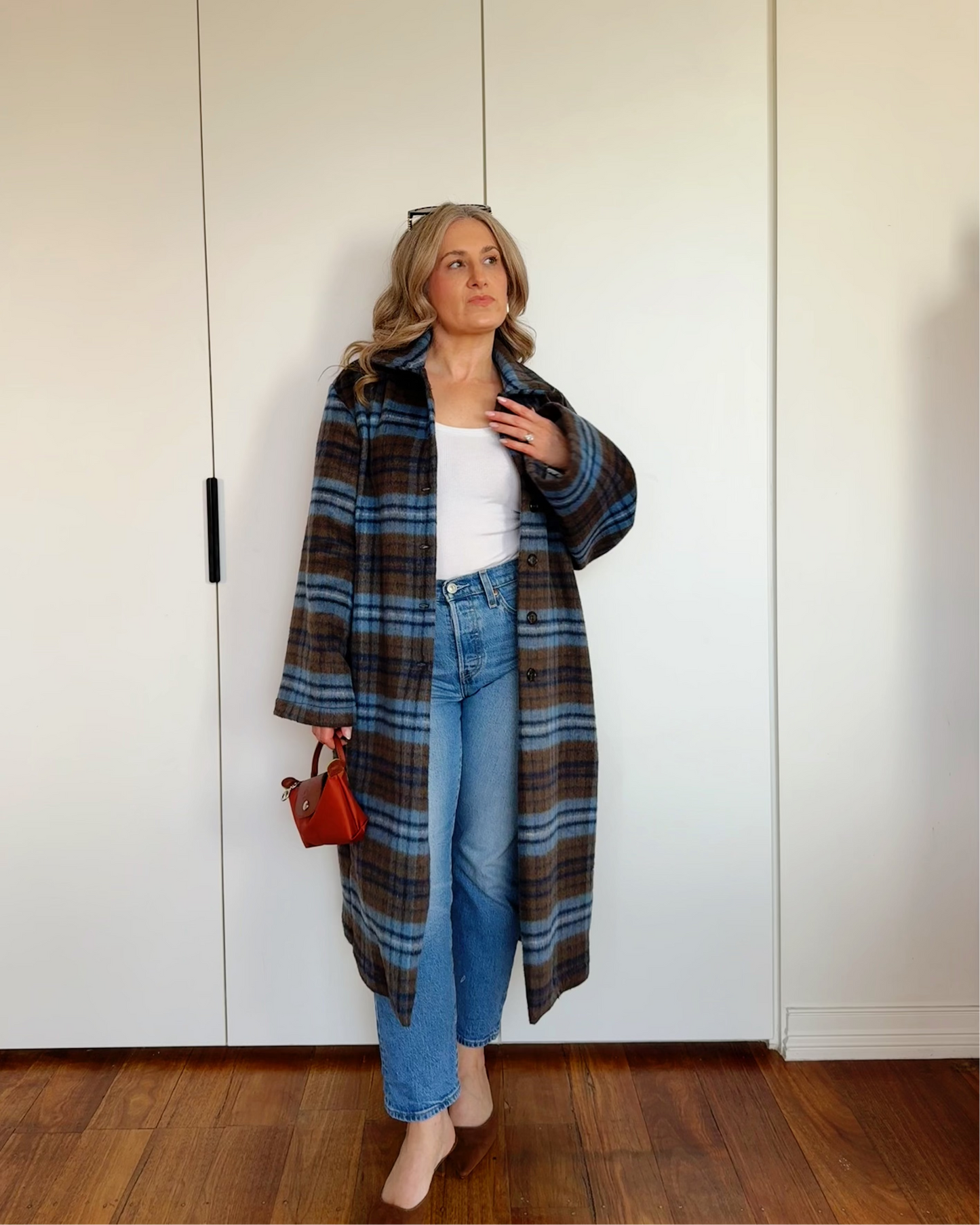 Model wearing The Tailored Coat by By Bel in an espresso and powder blue heritage check with a relaxed straight-cut silhouette
